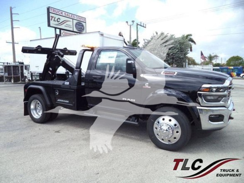 Ram 2500/3500 tow truck in black with large boom hoist, front grille, and winch equipment visible. Vehicle details readable on side: RAM, 4x4, heavy-duty chassis. TLC Truck Sales Center watermark.