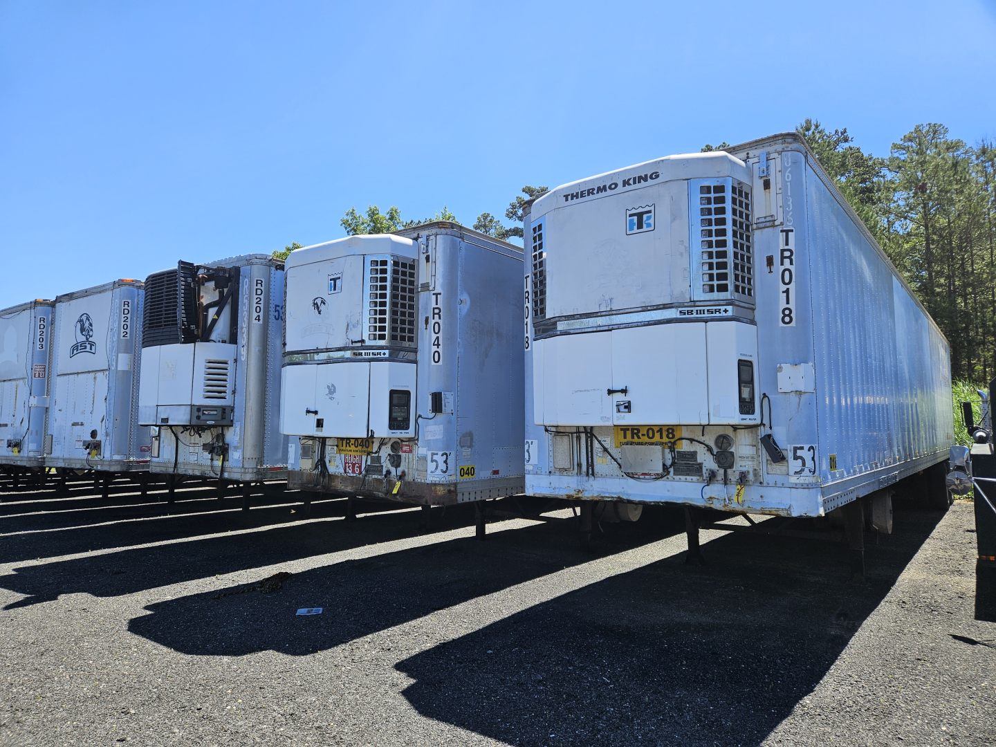 Fleet of refrigerated semi trailers (trailers) with Thermo King units, serial numbers and identification markings visible on doors and sides.