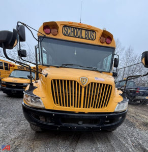 Front view of a yellow IC Corporation CE Series school bus with a prominent vertical grille, bumper, and 'SCHOOL BUS' sign on the roof.
