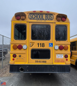 School bus rear view showing wheelchair accessibility indicator and compact spare tire compartments.