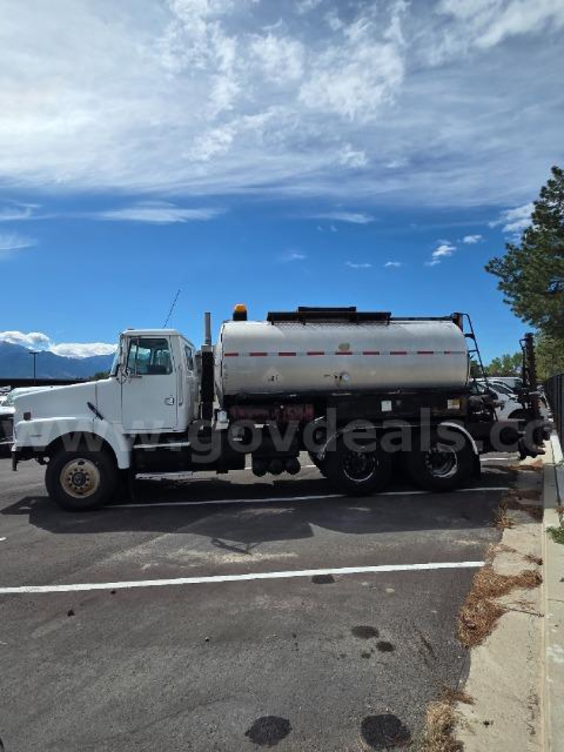 Volvo S2000 truck with a large cylindrical tank mounted on back, side view in parking lot.