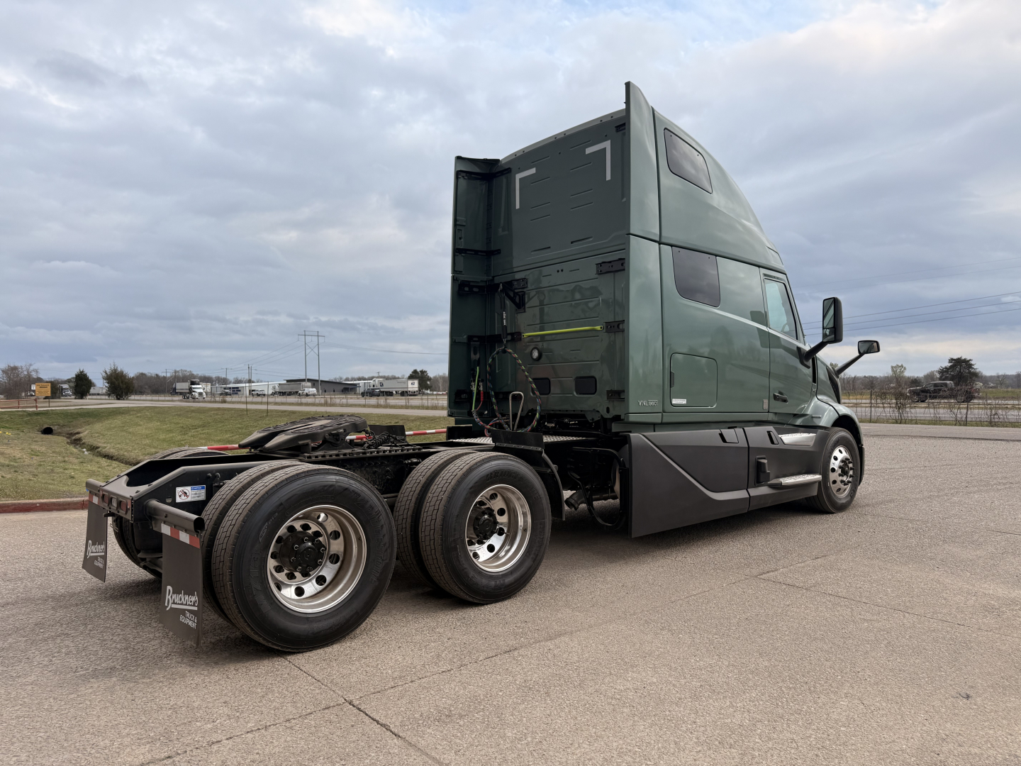 Volvo VNL64T860 cab and rear chassis view with dual rear axles, green exterior, sleeper cab, daytime exterior shot.