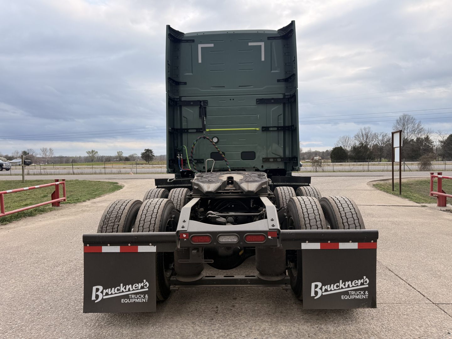 Volvo VNL64T860 tractor rear view showing fifth wheel, dual rear axles, mud flaps with Brackner's logo, and upright trailer coupling area.