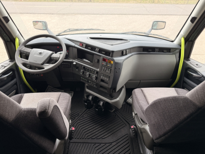 Volvo VNL64T860 truck interior cockpit view showing steering wheel, instrument cluster, center console, and two captain chairs.