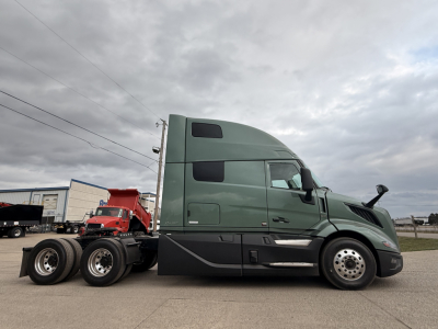Volvo VNL64T860 sleeper tractor side view showing green cab and tandem rear axles.