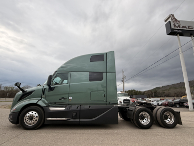Truck side view showing 2027 Volvo VNL64T860 conventional sleeper with green cab, dual rear axles, and side mirrors.