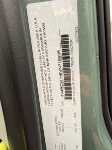 Vehicle information sticker on Volvo truck door: VIN 4V4BC9EH6VN719996, stock 71870, label with tags and barcode, classification includes ‘Truck Tractor’ and ‘Single Vehicle’ details.