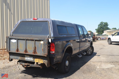 Ford F-350 Super Duty pickup truck with a long crew cab and utility bed, rear tailgate, faded blue paint, in-service appearance.