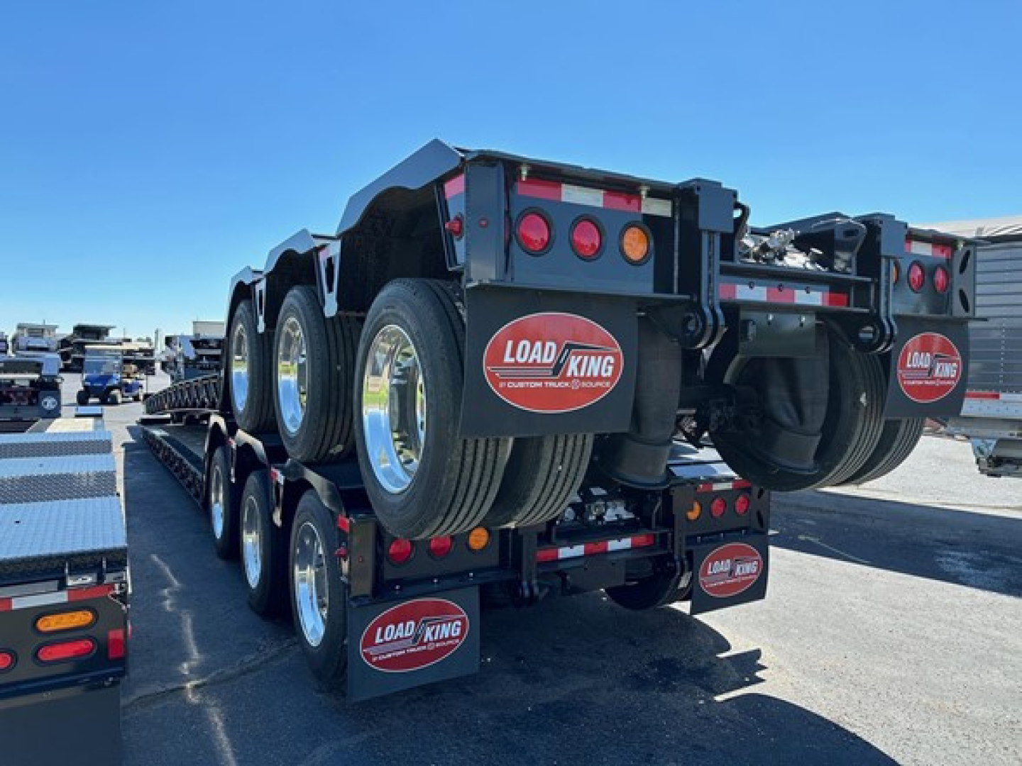 Load King lowboy trailer showing dual tires and rear deck with Load King logo mud flaps and taillights.