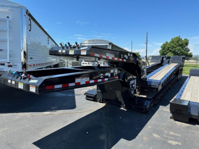 Load King 503-554-SS-SF lowboy trailer in a yard showing gooseneck and long flatbed sections with side rails and hydraulic components.