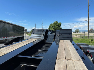 Load King trailer bed view showing wooden deck planks and black steel frame, 2027 model details not visible.