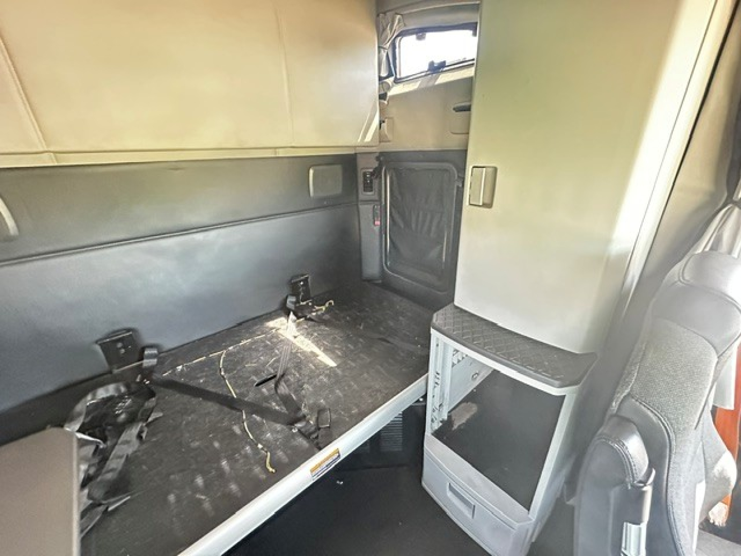 Kenworth T680 interior cabin area with sleeper berth and storage cabinet visible.