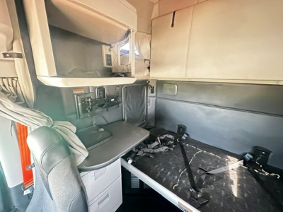 Kenworth T680 cab interior with sleeper area, bunk bed, and dashboard area visible.