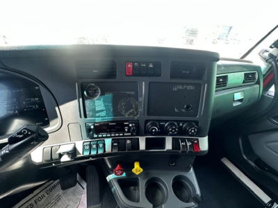 Kenworth T680 cab interior dashboard with controls, gauges, and cup holders visible.