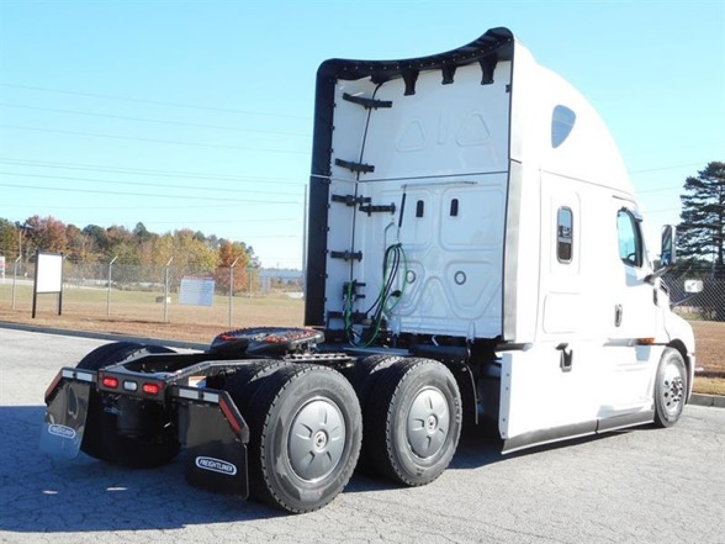 Freightliner Cascadia 126 tractor cab rear and side view showing sleeper truck chassis with dual rear axles.
