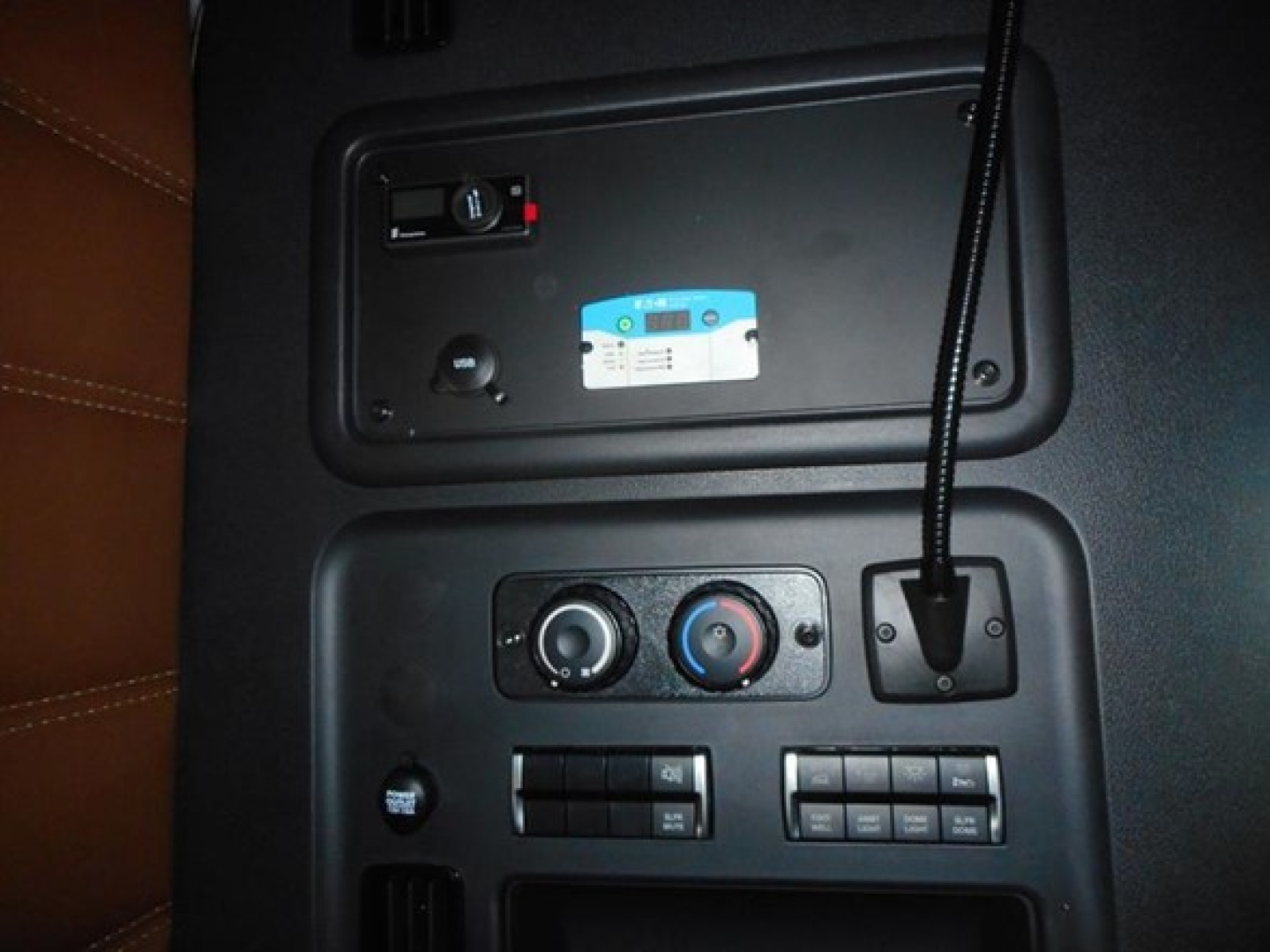 Cabin controls and USB/i/o panel of a Freightliner Cascadia cab showing climate controls and auxiliary ports.