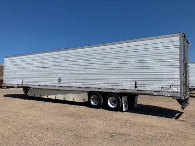 Trailer side view showing a 2012 refrigerated utility trailer with aluminum corrugated panels, tandem axle, and stock number placard visible.