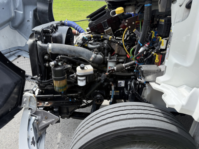 Kenworth T380 engine bay showing diesel engine, cooling system, hoses, wiring harness, and air filters in view.