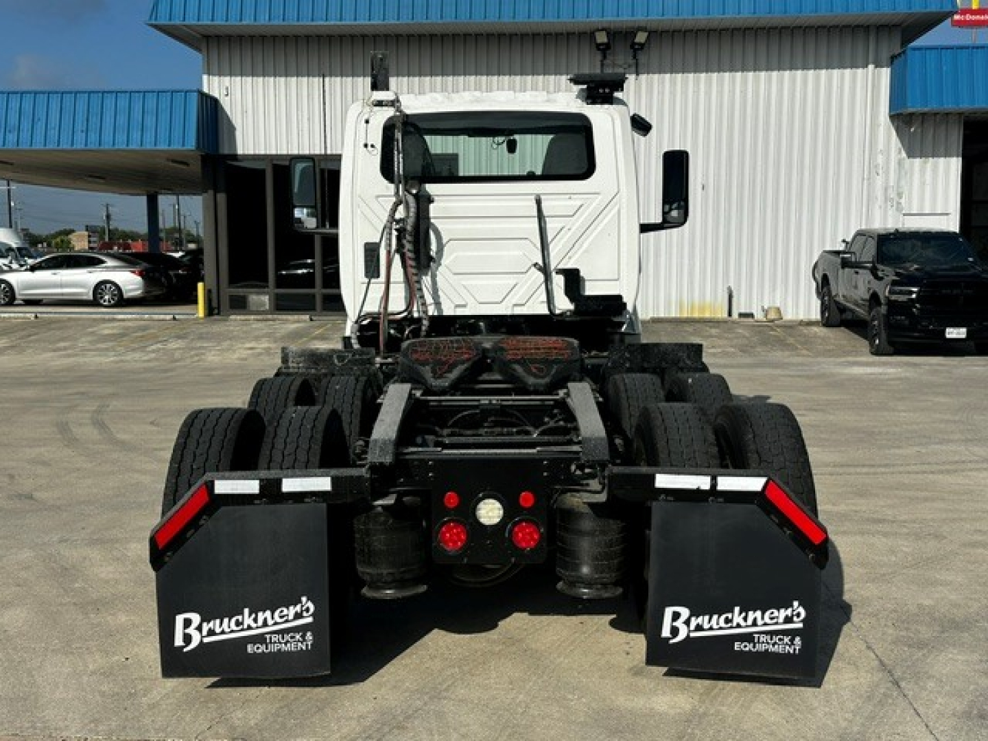 Truck chassis rear view showing mudflaps with Buckner's Truck & Equipment logos and taillights.