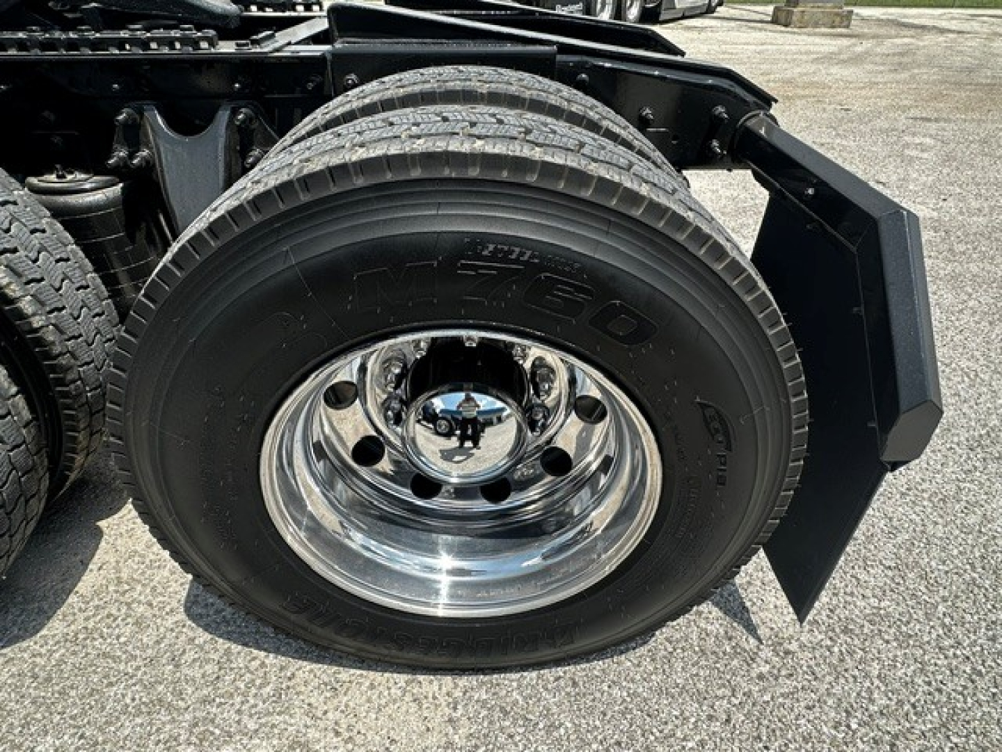 Truck wheel and fender view showing large RB tire and polished chrome rim with black mudguard and wheel well area.