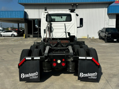 Truck chassis rear view showing mudflaps with Buckner's Truck & Equipment logos and taillights.