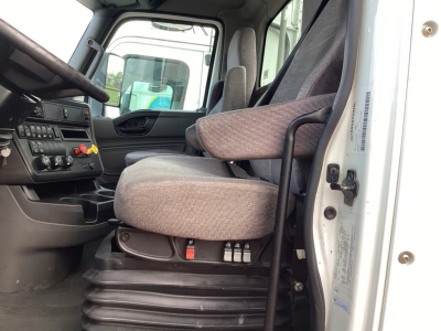 Truck cab interior of 2021 International LT625 showing driver seat and dashboard with controls and door trim.