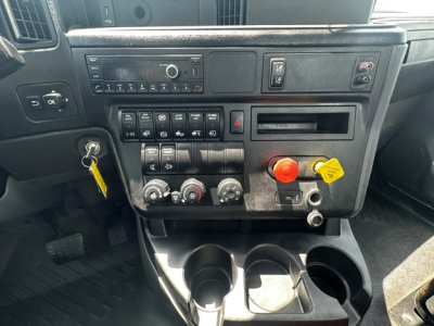 Truck dashboard center console with control panel, knobs, and cup holders in view.