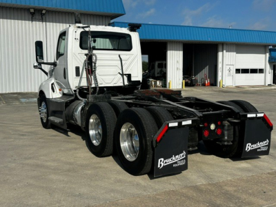 White International LT625 tractor in-service rear view showing 6-wheel configuration and rear mud flaps with Bruckner's branding.
