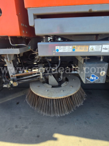 Sweeper attachment on Freightliner M2 112 showing a circular street-sweeper brush and hydraulic linkages.