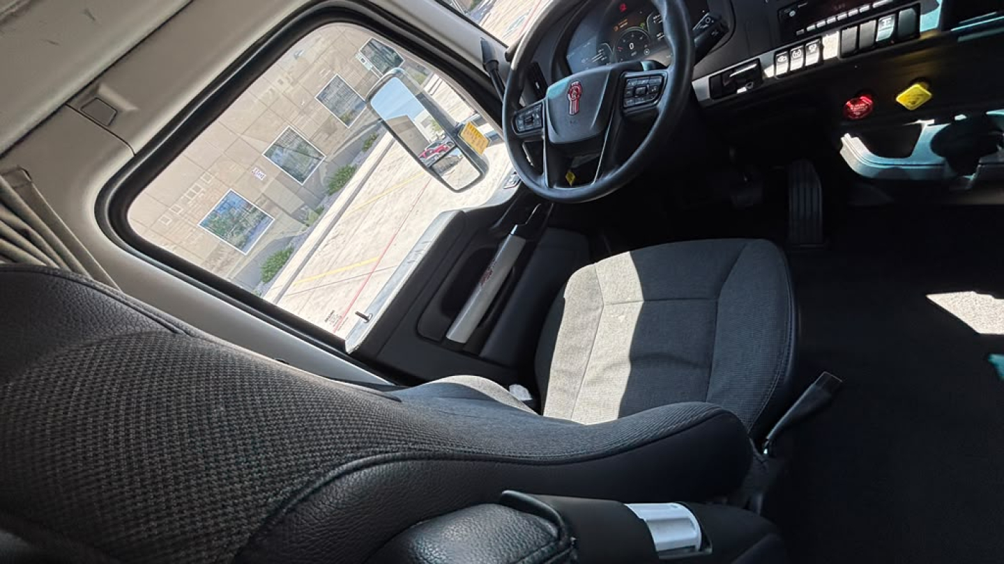 Kenworth T680 truck interior cabin and driver's seat view with steering wheel and dashboard