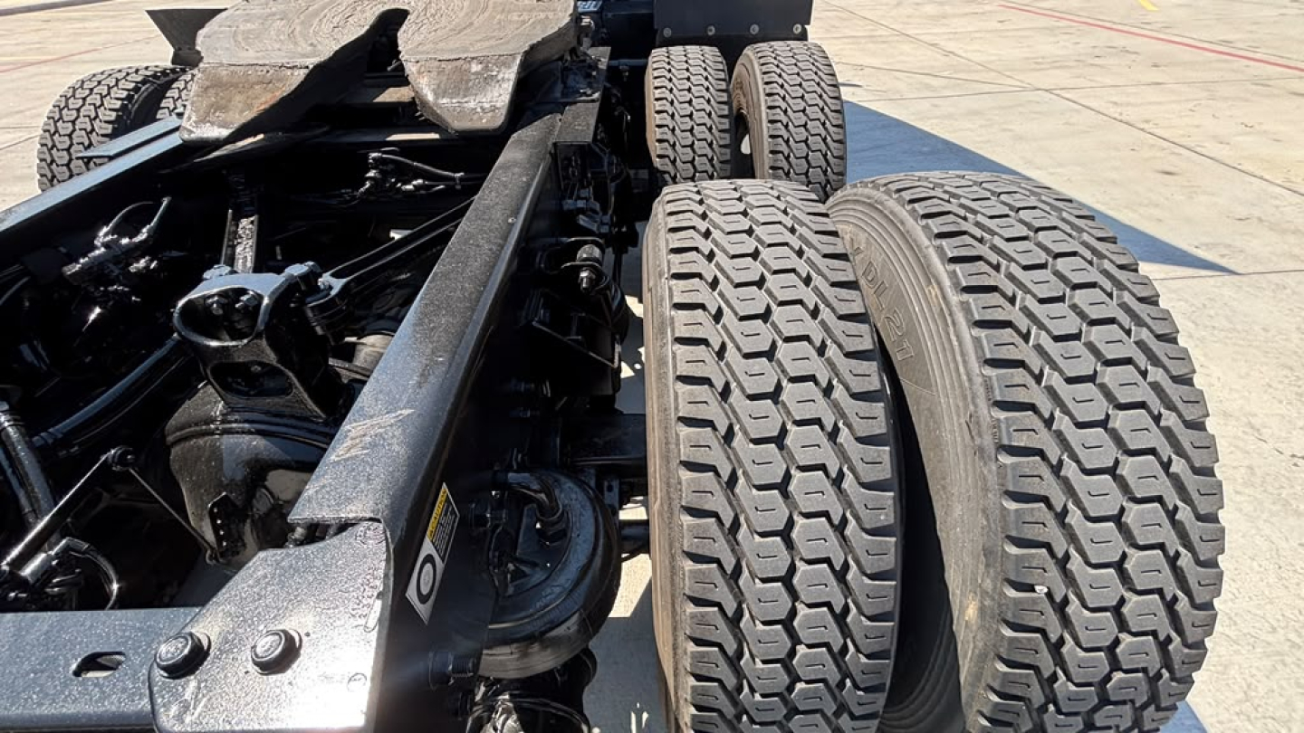 Kenworth T680 chassis showing dual rear axles and heavy-duty tires in view undercarriage and suspension components.