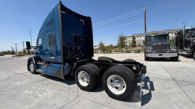 Kenworth T680 tractor side view showing dual rear wheels and fifth-wheel area with blue cab and sleeper, rear wheels and chassis visible.