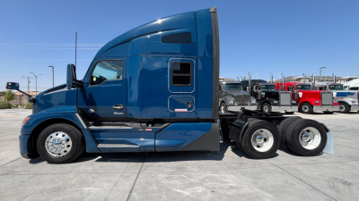 Kenworth T680 tractor in blue side view showing sleeper cab and rear wheels.