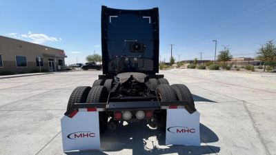 Truck rear view showing fifth wheel and dual rear axles with MHC mud flaps and rear bumper area.