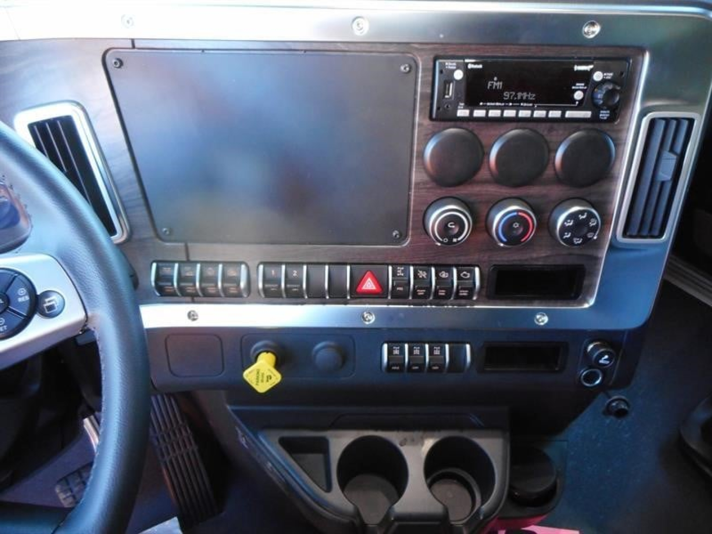 West Star 47X dash panel showing steering wheel, large blank panel, radio, climate controls, and cup holders.