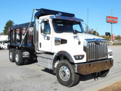 Western Star 47X dump truck in white and chrome front, side view, with heavy-duty bumper, dual rear axles, dump bed, and company logos on bed sides.