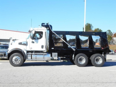 Western Star 47X dump truck side view showing white cab and black dump body with dual rear axles.