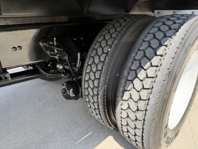 Kenworth truck rear dual tires and suspension shown in chassis area with black frame and wheel hub