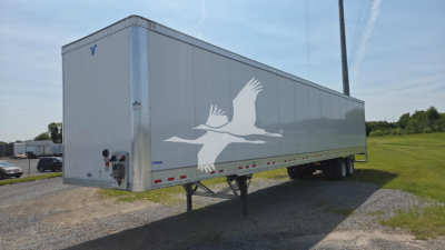 Trailer side view showing Vanguard VXP-High Base Rail logo graphic with bird silhouette on a light gray trailer.