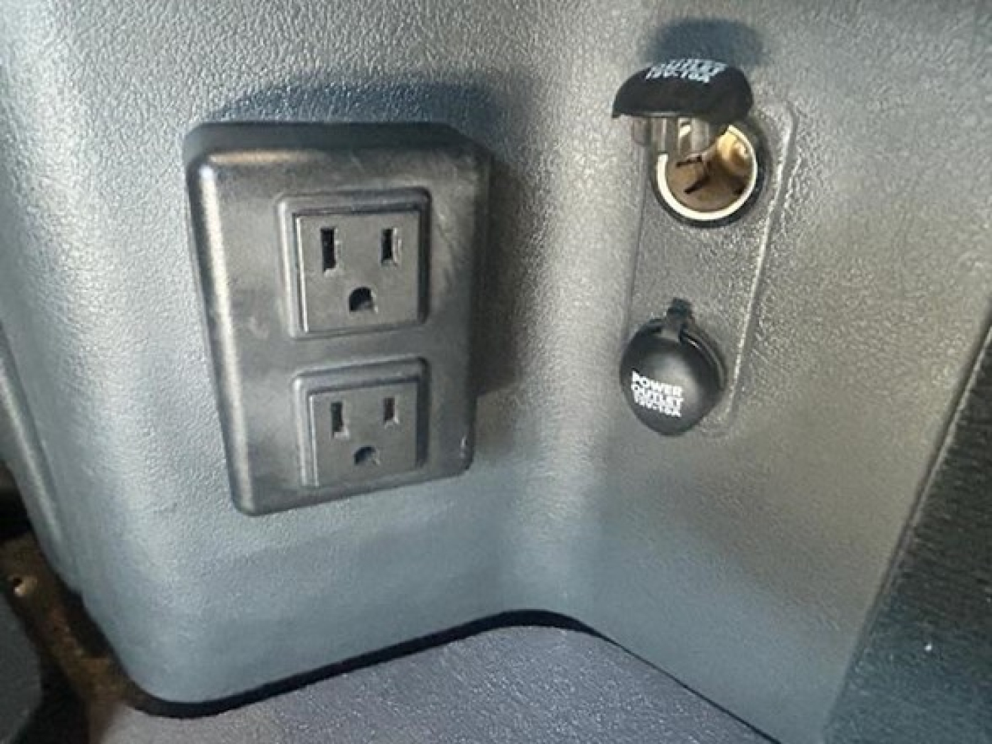 Freightliner Cascadia 126 truck interior showing two power outlets and 12V cig lighter with key cylinder nearby.