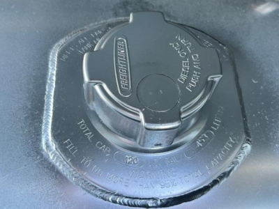 Fuel tank cap area on Freightliner Cascadia 126 showing diesel fuel cap with markings and warning text.