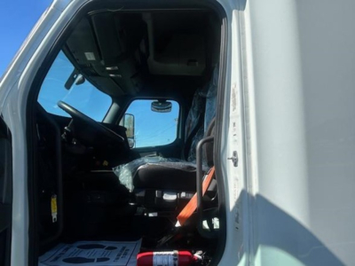 Cab interior of a 2023 Freightliner Cascadia 126 sleeper truck showing driver seat and dashboard from the open door.