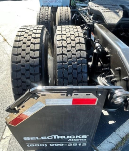Rear view of a 2023 Freightliner Cascadia 126 truck showing dual rear axles and wheel tires; SelectTrucks Atlanta plate with contact number visible.