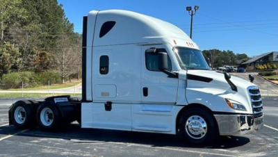 Truck cab side view showing a white 2023 Freightliner Cascadia 126 sleeper with glossy chrome wheels and dual rear axles.