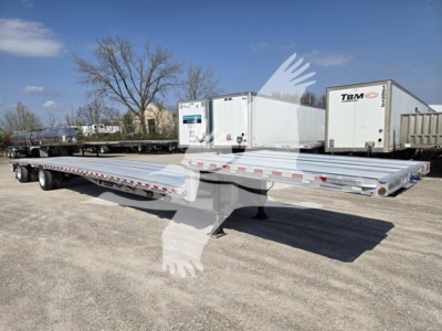 Trailer deck showing a 53-foot drop deck trailer with silver aluminum surface and red and white safety markings, multiple axles, with a white cab and a TBM cooler in background.