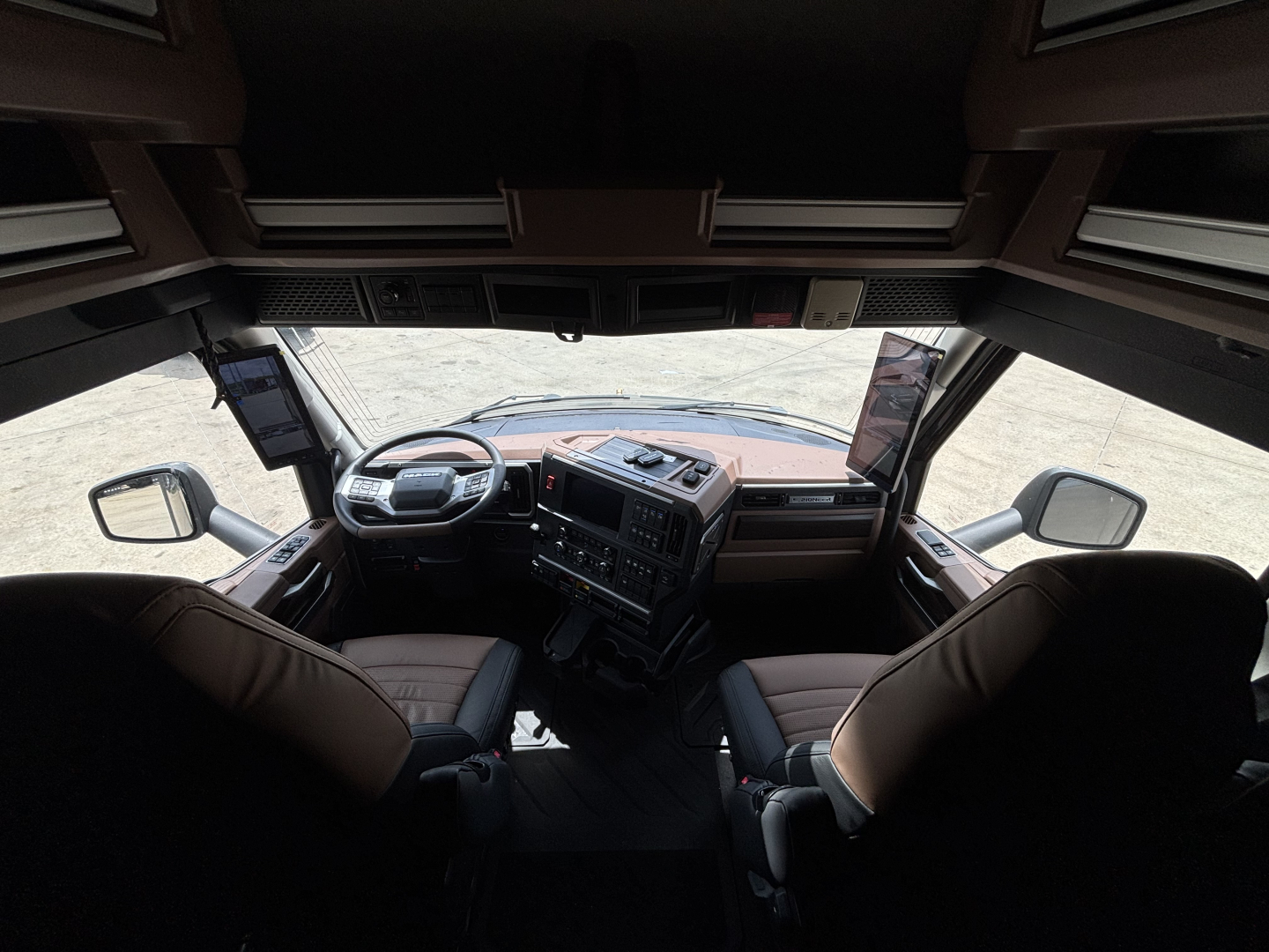 Truck cab interior of a 2027 Mack PR64T76H showing steering wheel, dashboard, and seats.