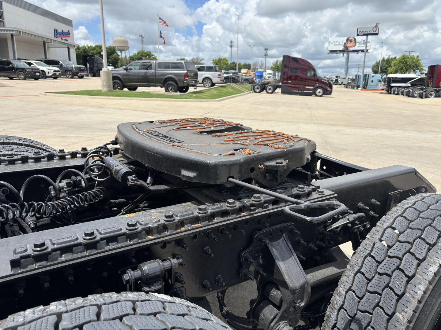 Mack PR64T76H drivetrain area showing fifth wheel hitch on a heavy truck chassis and dual rear axle with tires visible.