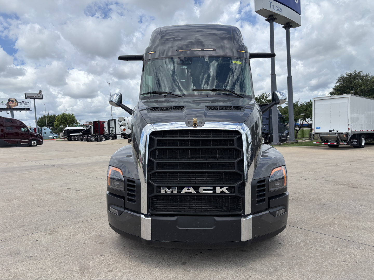 Front view of a new 2027 Mack PR64T76H conventional sleeper truck showing bold grille with MACK emblem and large bumper.