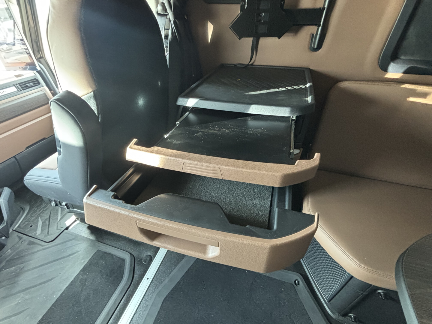Truck interior cab drawer set extended showing brown trim and storage compartments in the Mack PR64T76H cab.