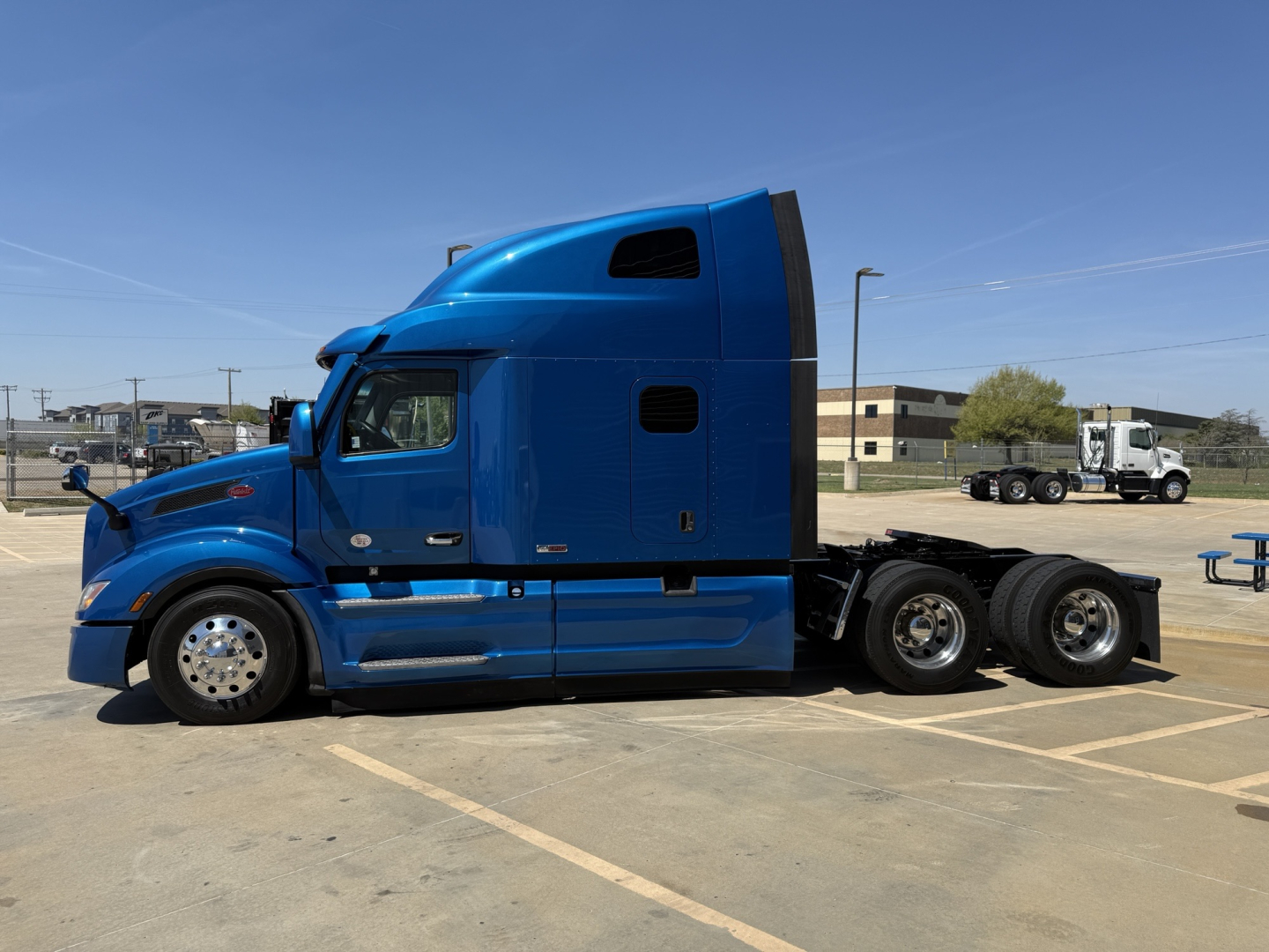 Peterbilt 579 tractor in blue side view showing sleeper cab and dual rear axles.
